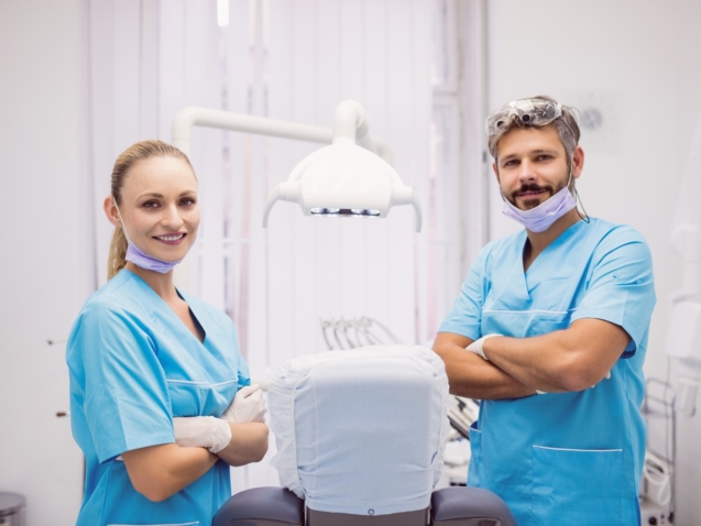 Portrait of dentist standing with arms crossed at dental clinic
