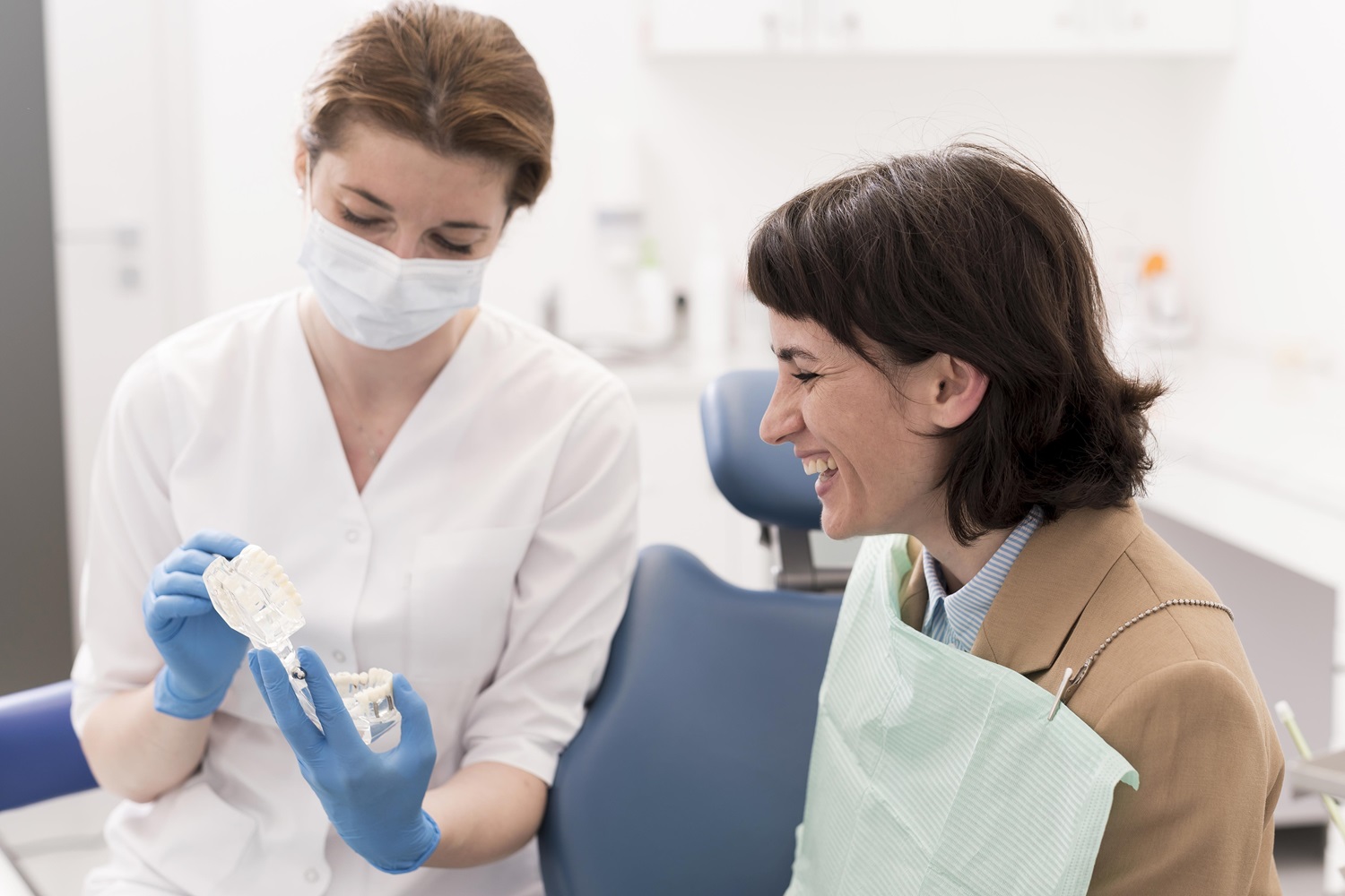 female-patient-looking-dental-mold-with-orthodontist